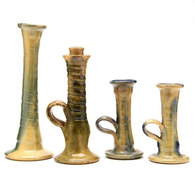 nc-art-pottery-a-group-of-four-candlesticks