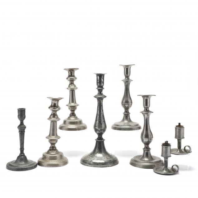 a-group-of-antique-pewter-candlesticks