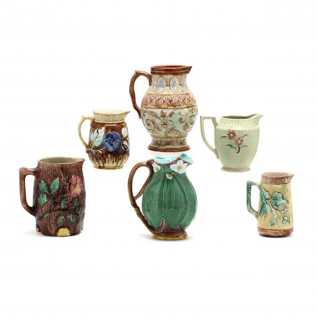 a-group-of-six-majolica-pitchers