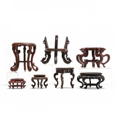 a-group-of-7-chinese-carved-wooden-raised-stands