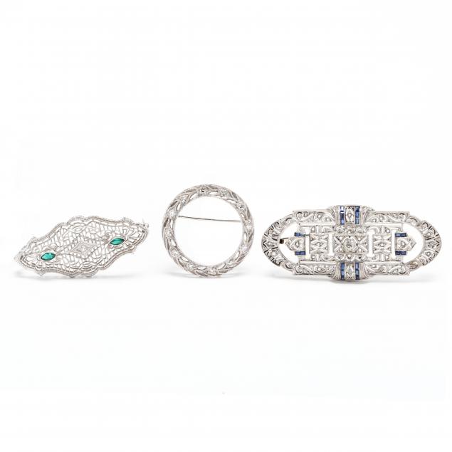 three-white-gold-gem-set-brooches