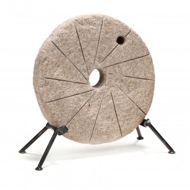 a-small-antique-millstone-on-stand