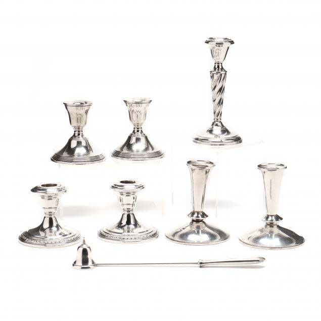 an-assembled-collection-of-seven-sterling-silver-candlesticks-a-snuffer
