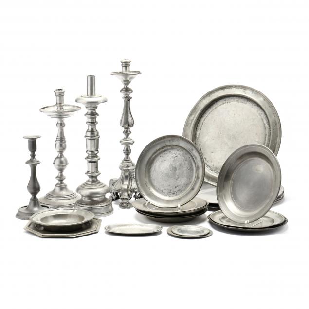 a-collection-of-twenty-antique-pewter-plates-and-candlesticks