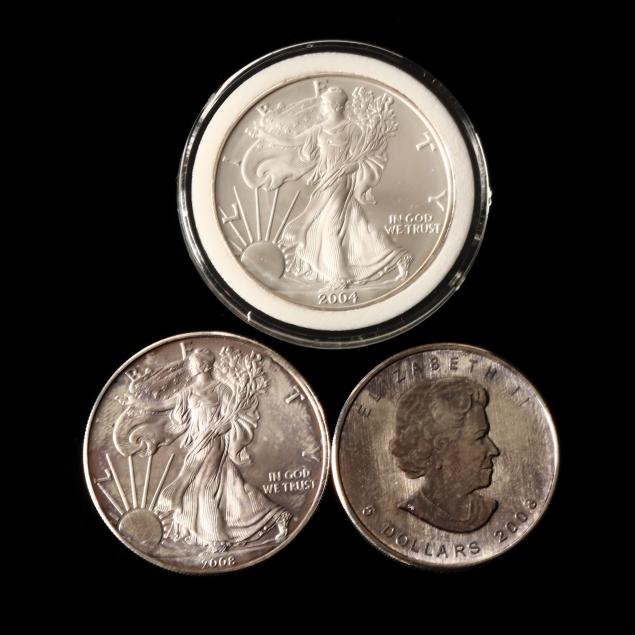 two-american-silver-eagles-and-a-canadian-maple-leaf