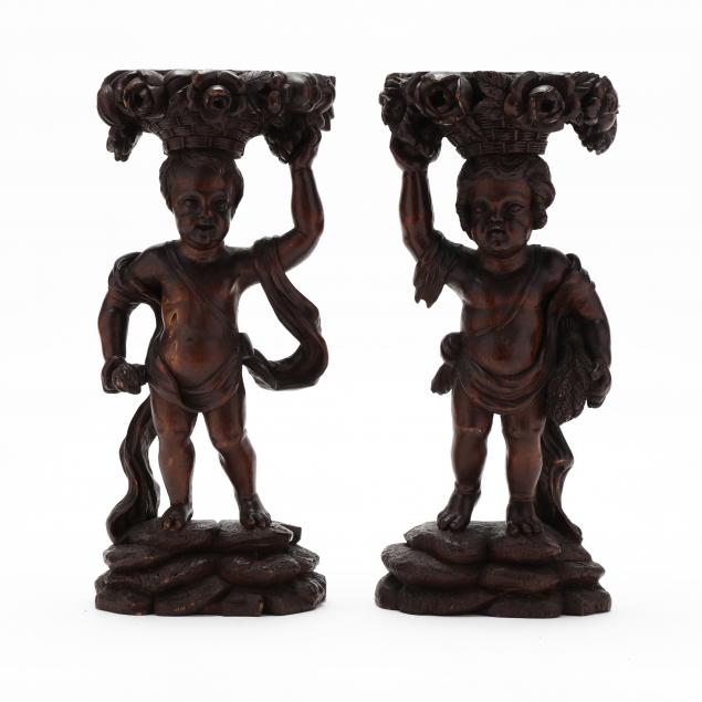 a-pair-of-carved-wood-stands-in-the-form-of-putti-with-baskets