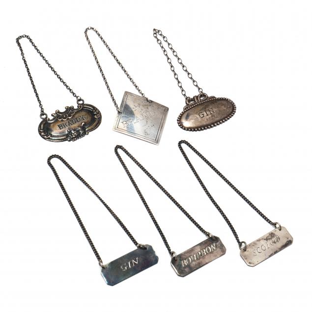a-collection-of-six-sterling-silver-decanter-tags