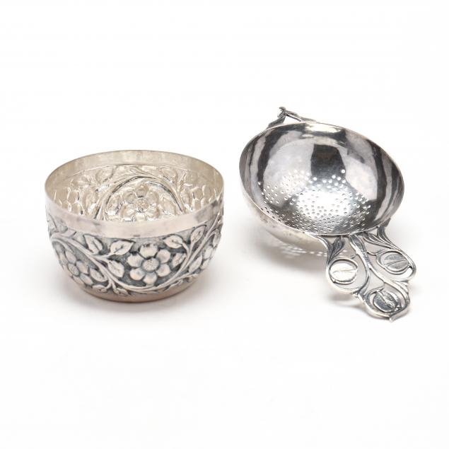 a-silver-tea-strainer-and-floral-cup