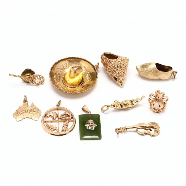 a-collection-of-gold-charms-and-a-tie-tack