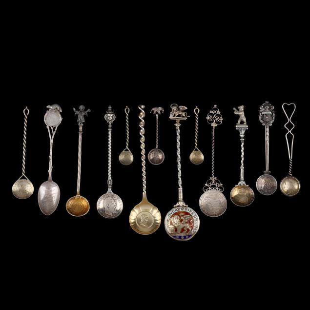 selection-of-silver-souvenir-spoons-featuring-international-currency