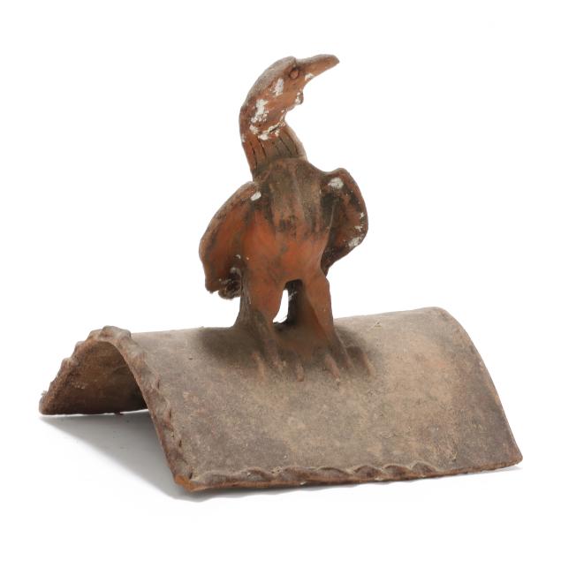 a-terracotta-roof-tile-featuring-an-alert-raptor