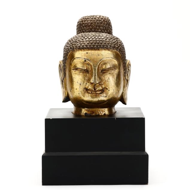 a-carved-and-gilt-stone-buddha-head-on-stand