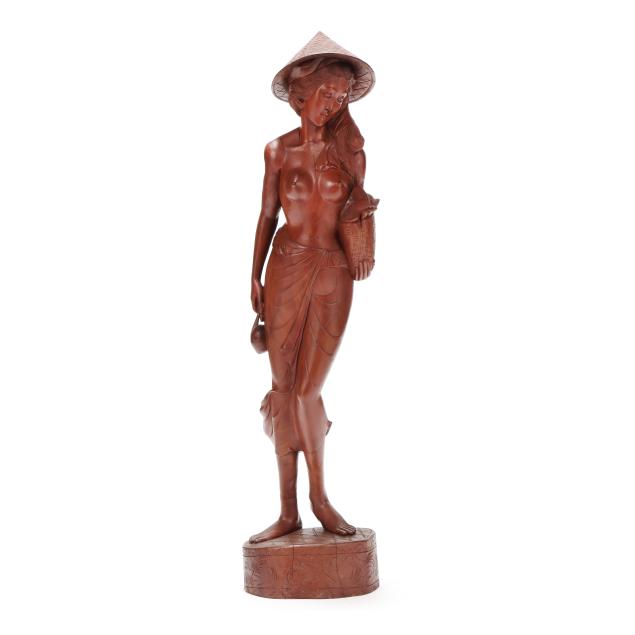 a-carved-wooden-southeast-asian-sculpture-of-a-women-with-a-basket