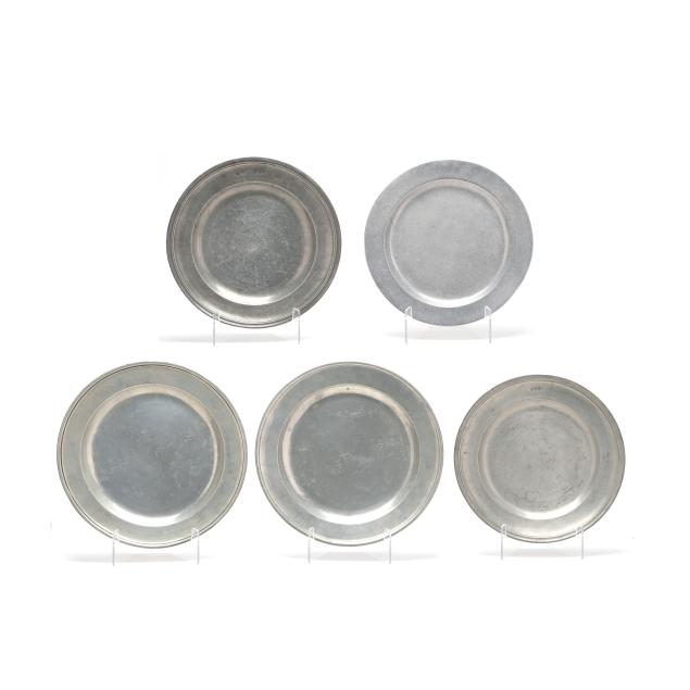 a-collection-of-five-pewter-and-metalware-chargers